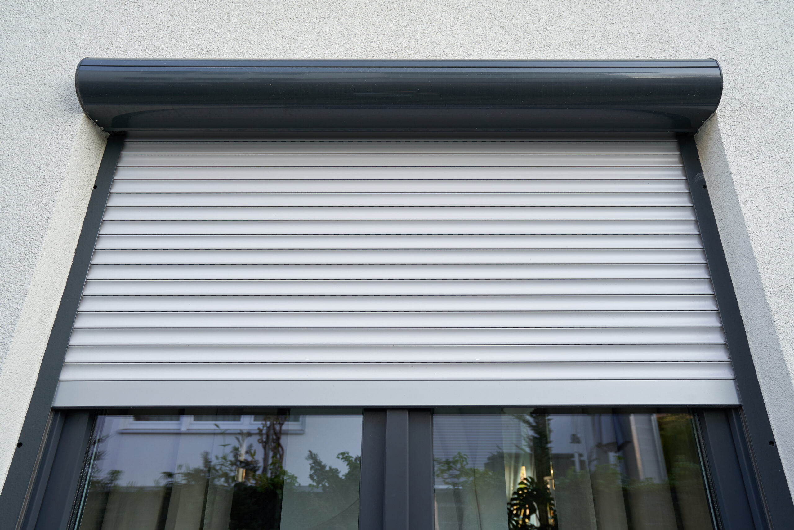 Roller shutter curtains mounted on a dark window