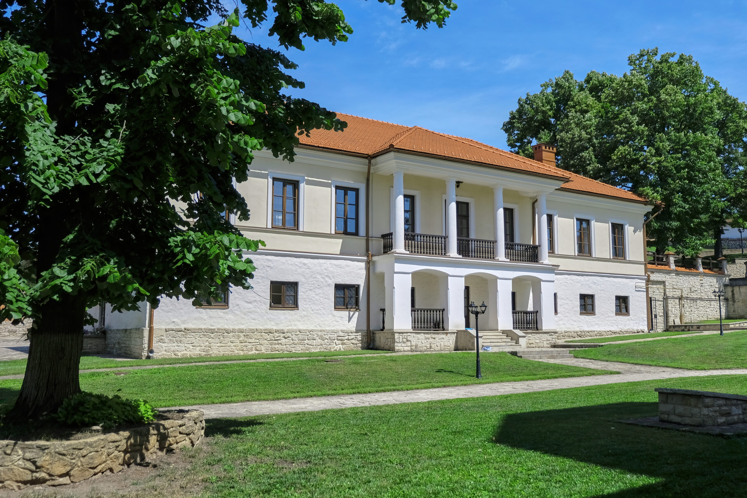 Courtyard of the monastery, building, grass and trees in Moldova